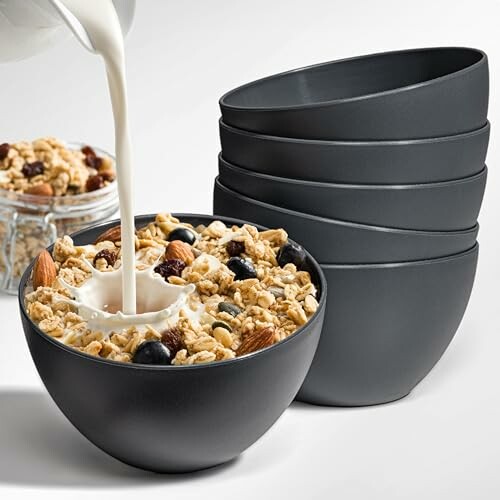 Melk wordt in een kom met muesli gegoten